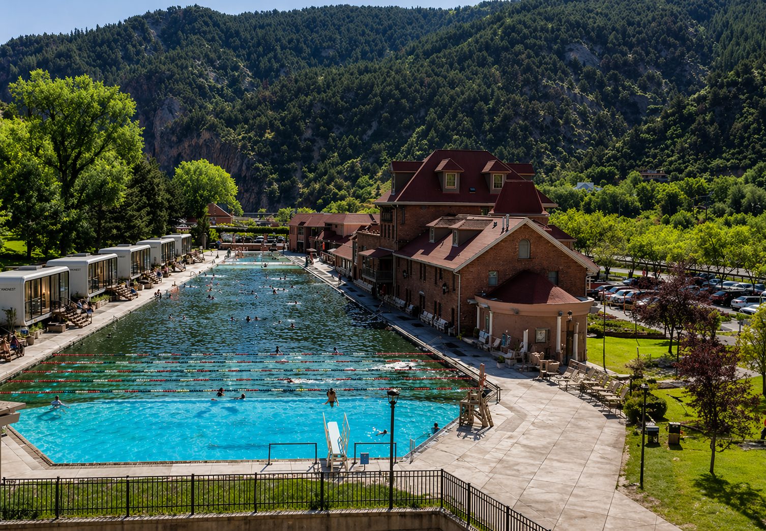 Modular resort cabins lining a mountain hot-springs pool